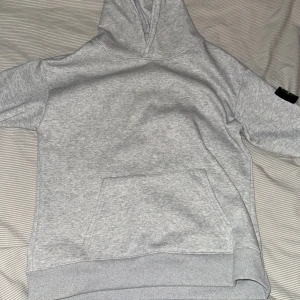 Grå hoodie från Stone Island - Säljer en stilren grå hoodie från Stone Island med deras ikoniska märke på ärmen. Knappt använd så skicket på den är som helt ny. Vid snabb affär kan jag gå ner i pris💯🧨