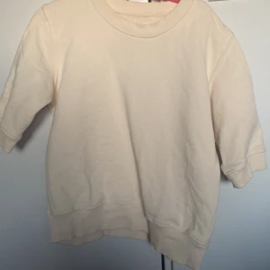 Beige sweatshirt - Säljer en stilren beige sweatshirt med normal passform. Tröjan har långa ärmar och ribbade muddar vid ärmslut och nederkant. Perfekt för en avslappnad look.