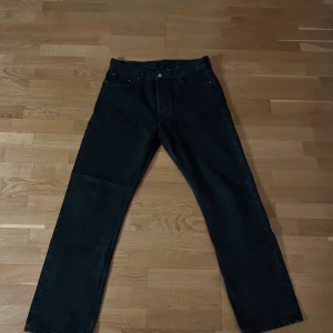 Svarta jeansbyxor från Weekday - Snygga svarta jeansbyxor från Weekday med en klassisk design. De har en rak passform och är perfekta för en avslappnad stil. Byxorna har en knapp och dragkedja framtill samt fem fickor. Märkeslappen i läder ger en extra touch. (Aldrig använda då de var för stora för mig)
