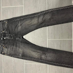 Levi's 501 - Snygga svarta jeans från Levi's med klassisk femficksdesign och knappgylf. De har en rak passform och är perfekta för en stilren look. Storlek: W30 L32