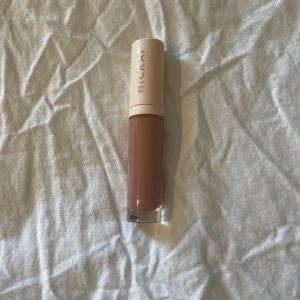 Nude läppglans från HICKAP - Snyggt nude läppglans från HICKAP i färgen Toasted Apricot med en elegant och stilren design. Aldrig använd då jag köpte fel färg. Köpt för 199kr Perfekt för en naturlig look med en touch av glans. Kommer i en praktisk tub som är lätt att ta med sig💕