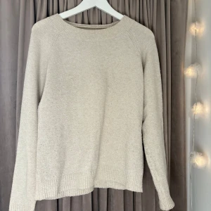 Beige stickad tröja - Mysig beige stickad tröja med rund hals och långa ärmar. Perfekt för kyligare dagar med ribbstickade muddar vid ärmslut och nederkant. Från vero mods
