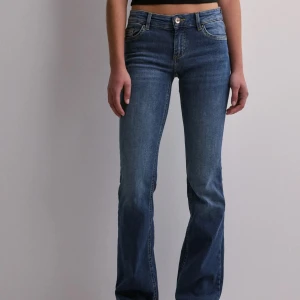 Lågmidjade jeans  - Snygga blå jeans från ONLY med klassisk femficksdesign och knappgylf. Perfekta för en avslappnad stil. Lågmidjade och bootcut, Stl s/30. Max använda 5 gånger så jättebra skick💕