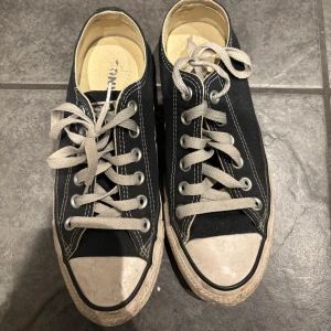 Svarta sneakers från Converse - Klassiska svarta Converse All Star sneakers med vita snören och sula. Perfekta för en avslappnad stil. De har den ikoniska loggan på hälen och en bekväm passform.