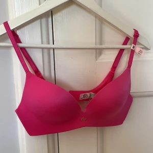 Rosa bh från Victoria Secret  - Snygg och bekväm rosa bh från Victoria Secret med justerbara axelband och en liten dekorativ detalj framtill. Perfekt för en färgglad och stilren look. Push up Bh. HELT NY