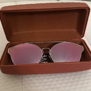 Solglasögon från Missoni - Snygga solglasögon från Missoni med silverfärgad ram och rosa tonade glas. Skalmarna har ett coolt randigt mönster i rosa och lila. Perfekta för att ge din stil en extra touch och perfekt nu till sommarn!🩷