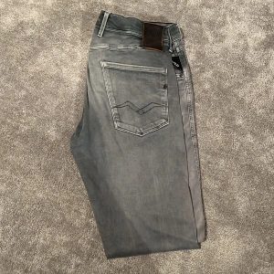 Grå jeans från Replay - Snygga grå jeans från Replay med en klassisk femficksdesign. De har en normal passform och är tillverkade i ett slitstarkt material. Perfekta för en stilren look. Fint skick 7/10 inga stora eller tydliga skador