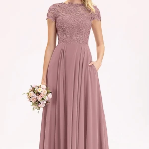 Rosa spetsklänning från JJ's House - Elegant långklänning i rosa från JJ's House med vacker spetsdetalj på överdelen och korta ärmar. Klänningen har en rund hals och en liten öppning i ryggen. Perfekt för speciella tillfällen.