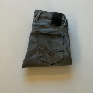 Replay anbass  - Snygga grå jeans från Replay med en modern slim passform. De har en klassisk femficksdesign och en diskret logga på bakfickan. Perfekta för en stilren look. Inga defekter 