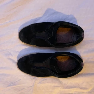 Eytys  - Snygga svarta sneakers från Eytys i mocka med en stilren design. Skorna har en vit sula som ger en fin kontrast och en bekväm passform. Perfekta för en avslappnad stil. Har lagats i hälen 