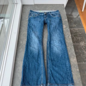 Lågmidjade bootcut jeans - Bootcut jeans med låg midja. Jeansen har dekorativa sömmar på bakfickorna. Midjemått: 44 cmx2. Innerbenslängd: 80 cm. Grensöm: 20 cm.                                                             Skriv om ni har några frågor☺️(bilderna är lånade)