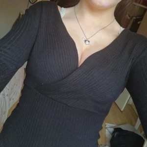 Svart ribbad omlottopp från NLY Trend - Säljer en skit snygg svart ribbad omlottopp från NLY Trend i storlek S. Toppen har v-ringning och är tillverkad i ett stretchigt material som sitter snyggt på kroppen. Perfekt till många olika outfits, och inte använder mycket. Pris kan absolut diskuteras☺️❤️