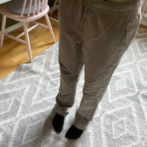 Beige linnebyxor från 157 - Grå gröna,  linnebyxor från 157 med resår i midjan och raka ben. Har fickor fram och bak. Storlek S, bra skick. 