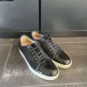 Blåa lanvins - Säljer ett par mörkblåa sneakers från Lanvin. Skorna har skorna är i bra skick utan några defekter! Skriv för mer frågor och annat!