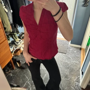 Röd v-ringad blus med volangärmar - Säljer en röd blus med v-ringning och volangdetaljer vid axlarna. I jättebra skick❤️