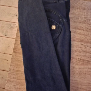 Freddy wr up  - Säljer ett par mörkblå jeansbyxor med klassisk femficksdesign. Byxorna har raka ben och normal passform, perfekta till vardags. Snygg och enkel stil som funkar till det mesta.