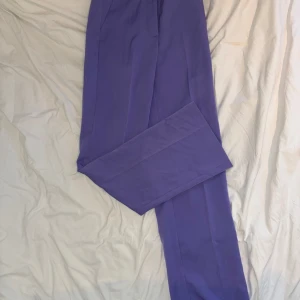 Lila kostymbyxor från Bik Bok - Snygga lila kostymbyxor från Bik Bok med raka ben. Hög midja, storlek 34