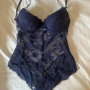 Mörkblå spetsbody från H&M - Säljer en mörkblå body i spets från H&M med push up, aldrig använd då jag haft liknande i svart. Slutsåld på hemsidan🩷
