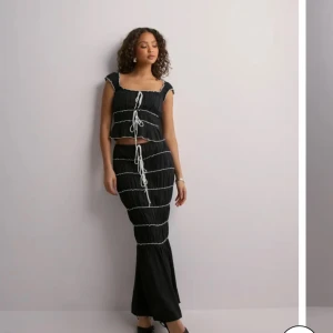 Svart set med vita detaljer - Snyggt svart set med vita detaljer. Från Nelly, endast testad. Nypris:700 kr