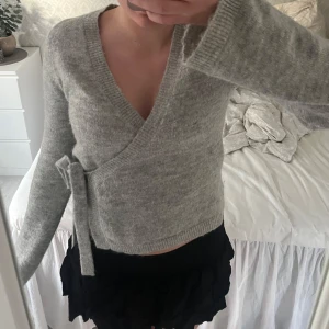 Grå omlottkofta - Säljer min super fina tröja med knyt på sidan från gina💕Aldrig använd och är helt ny säljer då den inte kommer till användning! Storlek S men passar även M