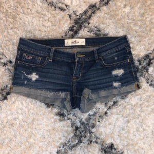 Mörkblå lågmidjade jeansshorts från Hollister - Säljer nu dessa jättefina jeansshort från Hollister i storlek w27! Jättecoola slitningar och lågmidjade, perfekta jeansshortsen till sommarn💕🌺🌼