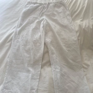 Vita linnebyxor från Gina Tricot - Säljer ett par vita linnebyxor som blivit för små, från Gina Tricot med resår och snöre i midjan. Byxorna har raka ben och är tillverkade i ett tunt och luftigt material, perfekta för varma dagar. Innerbenet är 67 cm och från midjan till slutet är 89 cm. 24 cm i benen. Kontakta gärna innan köp!💕