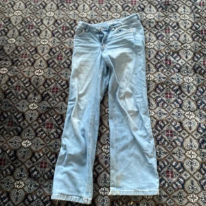 Ljusblå jeans med raka ben - Säljer ett par ljusblå jeans med raka ben och klassisk femficksdesign. Jeansen har normal passform och stängs med dragkedja och knapp. Perfekta för en avslappnad stil.