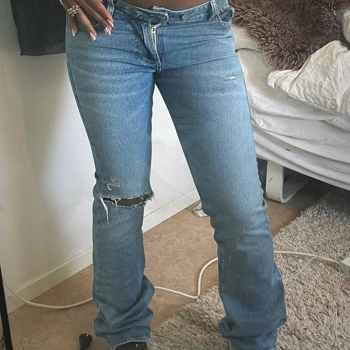 Blåa jeans med hål på knät och lår