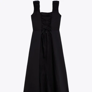 Svart långklänning med snörning baktill - [Bilden visar klänningen baktill] Säljer en svart långklänning med breda, rynkade axelband och snygg snörningsdetalj baktill. ENDAST ANVÄND EN GÅNG!