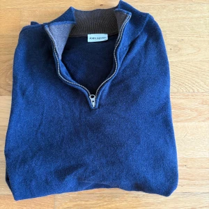 Marinblå halvziptröja John Henric - Snygg marinblå tröja från John Henric i 100% bomull. Tröjan har en klassisk half zip-dragkedja och ribbad brun insida vid kragen. Den passar dig som är allt från 175 och 185. Bara att skriva vid frågor eller funderingar!