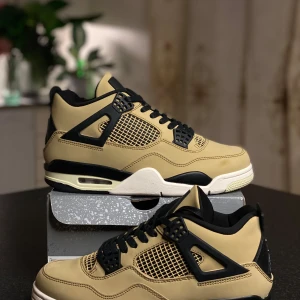 Nike Air Jordan 4 Retro Taupe - Säljer ett par Nike Air Jordan 4 Retro i beige och svart med coola meshdetaljer och svarta plastpaneler. Skorna har snörning, synlig Air-sula och den klassiska Jumpman-loggan på hälen. Perfekta för dig som vill sticka ut med en ikonisk sneaker.