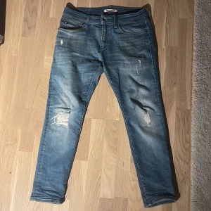 Blå slitna jeans  - Snygga blå jeans med slitningar och har använt 10 gånger de har passformen slim fit 
