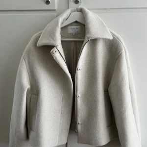 Stockh LM kort kappa  - Vit kappa från Stockh LM i ull. Använd en gång och därav i nyskick, nypris 1499. Strl. xs men har en något större passform vilket funkar bra för mig som vanligtvis har s, alt. kan ha tjocka tröjor under jackan.