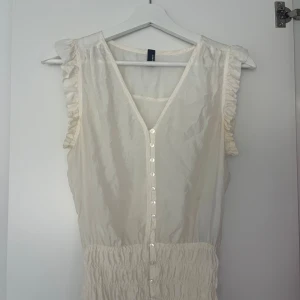 Vit topp från Vero Moda - Vit tunn topp med v-utringning och knappar, står ingen storlek på lappen men passar mig som använder 34/36 bra. 