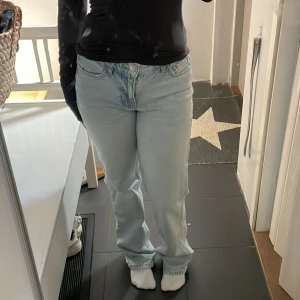 Ljusblå raka jeans från Gina Tricot  - Säljer ett par ljusblå jeans från Gina Tricot med klassisk femficksdesign och raka ben. Jeansen har normal/låg midja och är tillverkade i bomull. Perfekta för en avslappnad och trendig look. De är större i storleken så de passar för storken 34 med, jag har normalt 34 och de passar mig bra🫶🏻🫶🏻