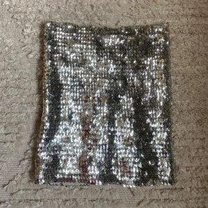 Silvrig tubtopp med paljetter - Säljer denna supersnygga silvriga tubtopp med paljetter! Perfekt till fest eller skivor med glitter/ discotema!😍😍