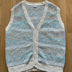 Stickad väst Zara - Superfin stickad väst från Zara i mix av beige, grått och ljusblått. V-ringad modell med ribbade kanter och fyra knappar framtill. Perfekt att slänga över en t-shirt eller skjorta för en chill och trendig look. Information, bilder och prisdiskutering i dm.