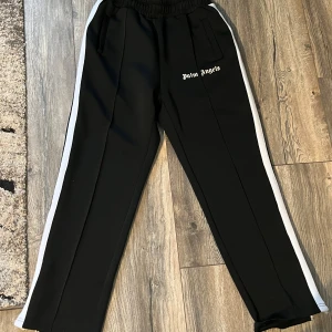 Palm Angels Byxor - Säljer dessa Palm Angels trackpants i svart. Använda men i fint skick. Säljer eftersom de inte är min stil längre.