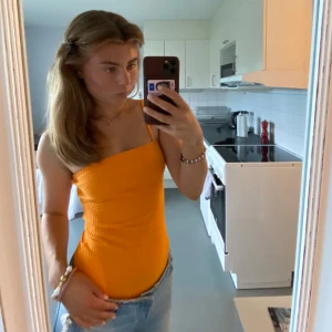 Body - En fin body från BikBok i orange. Sitter bekvämt och är i gott skick. 