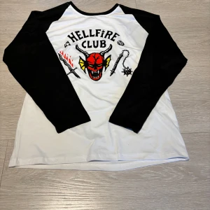 Hellfire Club långärmad tröja - Säljer en oversized svartvit långärmad tröja med Hellfire Club-tryck framtill.