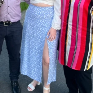 Blommig blå långkjol från & Other Stories - Supersöt blå långkjol från & Other Stories med vita små blommor över hela tyget. Kjolen har en slits framtill och dragkedja i sidan. Endast använt fåtal gånger 