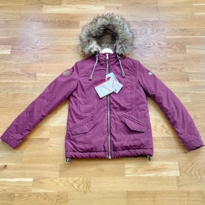 Ny Dolomite Vinröd Vinterjacka med tags - Helt ny aldrig använd med etiketter kvar Parkajacka från Dolomite med mysig avtagbar päls runt huvan. Perfekt för kalla dagar när du vill hålla stilen och värmen. PRIS KAN DISKUTERAS.