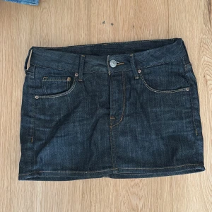 Mörkblå jeanskjol med fickor - Snygg mörkblå jeanskjol med klassiska fem fickor och kontrastsömmar. kjolen är i barnstrolek 146 men skulle säga att den passar xxs 