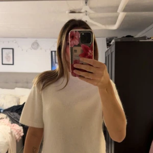 Vit stickad kortärmad tröja - Supermjuk och fluffig vit stickad tröja med korta ärmar och rund hals. Enkel och clean design som är lätt att matcha med allt. Perfekt för lager-på-lager eller som den är när det är lite kyligare ute.