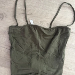 Olivgrön topp med smala axelband - olivgrön Croppad topp med smala axelband. Storlek xs från divided