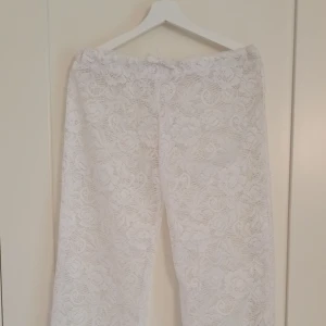 Handgjorda vita spetsbyxor lågmidja - Säljer dessa lågmidjade spetsbyxor som jag sytt själv. Perfekt med vita shorts under! Vida ben och snöröjning i midjan💕 passar storlek XS/S.
