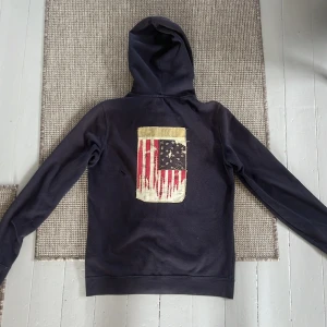 Ralph lauren denim & supply hoodie - Mörkblå zip hoodie från Ralph Lauren denim & supply. Bra skick förutom ett litet hål i ryggen som knappast syns, därav priset. Strl S 