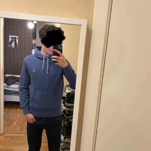 Ralph Lauren Hoodie - Säljer en blå hoodie från Polo Ralph Lauren med klassisk huva och dragsnören. Tröjan har en broderad logga på bröstet och är tillverkad i mjuk bomull.