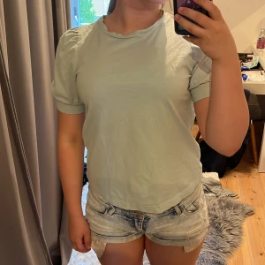 Ljusgrön t-shirt  - Supersöt ljusgrön tröja  med korta puffärmar och rund hals. Enkel och stilren design som passar perfekt till jeans eller shorts. Mjuk och skön känsla, perfekt för varmare dagar.