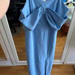 Ljusblå balklänning med rosett från WalG - använd 1 gång 